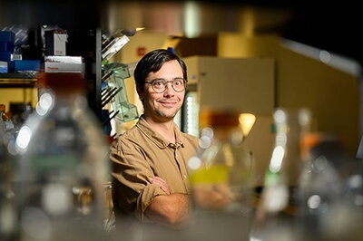 Chris Brooke in lab surrounded by beakers and other bottles